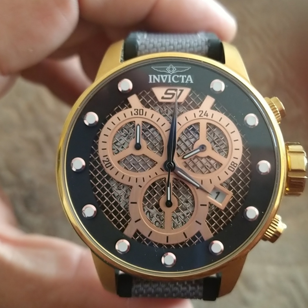 Invicta watch gold w black strap and white lining.